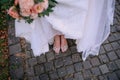 Bride feet shoes bouquet stone road outside Royalty Free Stock Photo