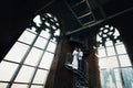 Bride and fiance standing on the spiral stairs in old Gothic cat Royalty Free Stock Photo