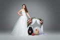 Bride girl with dog wedding couple under flower arch Royalty Free Stock Photo