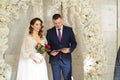 bride and groom in an arch of flowers at ceremony with a marriage certificate. Royalty Free Stock Photo