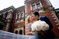 Bride and groom on the background of an old estate. Classical wedding. Wedding walk and photo shoot. Embraces and kiss Royalty Free Stock Photo