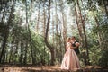 Bride and groom on the background of trees and woods in full growth