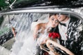 The bride and groom behind the wheel of retro car. Wedding. Royalty Free Stock Photo