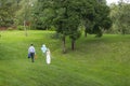 Bride and groom with blue balloons and picnic basket near apple trees