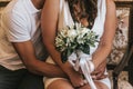 Bride and groom in a cafe. wedding bouquet on a wooden table in a restaurant bride and groom hold each other`s hands Royalty Free Stock Photo