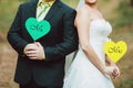 Bride and groom with cards in shape of heart Royalty Free Stock Photo