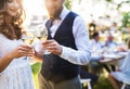 Bride and groom clinking glasses at wedding reception outside in the backyard. Royalty Free Stock Photo