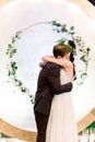 Bride and groom, couple in love, hugging and kissing, during the night wedding ceremony, near the arch in the eco rustic Royalty Free Stock Photo