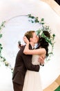 Bride and groom, couple in love, hugging and kissing, during the night wedding ceremony, near the arch in the eco rustic Royalty Free Stock Photo