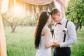 The bride and groom cuddling in the rays of the evening sun. Wedding ceremony.