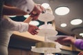 Bride and groom cut rustic wedding cake on wedding banquet with red rose and other flowers. Royalty Free Stock Photo