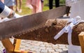 Bride and groom cutting wood log on sawhorse at wedding day Royalty Free Stock Photo