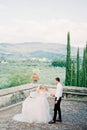 Bride and groom dance near the stone fence in the garden