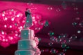 Bride and groom doll on the top of wedding cake with bubble soap in hotel room