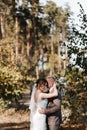 Bride and groom embracing each other at the background of the trees in the forest. Bride and groom portrait Royalty Free Stock Photo