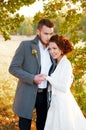 Bride and groom embracing. Romantic autumn outdoor setting. Royalty Free Stock Photo