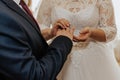 The bride and groom exchange rings. A man puts a wedding ring on a woman& x27;s hand. Royalty Free Stock Photo