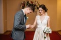 The bride and groom are exchanging wedding rings in the registry office