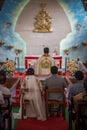 Bride, groom, family, and friends attending the Catholic wedding ceremony. Religious celebration at church in Kerala province in