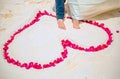 The bride and groom feet enter the heart of the rose petals