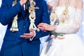 Bride and Groom in formal costumes with flower garlands, looking nervous, were interviewed on the stage in traditional Thai
