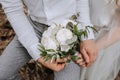 The bride and groom gently hold hands. They are holding a bouquet of peonies Royalty Free Stock Photo