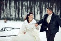 Bride and groom have fun running across a park in the snow weather Royalty Free Stock Photo