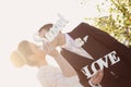 Bride and groom having fun and posing with Sweet Love letters in sunlight Royalty Free Stock Photo