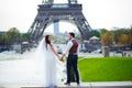 Bride and groom having a romantic moment on their wedding day in Paris, in front of the Eiffel tour Royalty Free Stock Photo