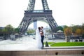 Bride and groom having a romantic moment on their wedding day in Paris, in front of the Eiffel tour Royalty Free Stock Photo