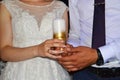 Loving bride and groom hold a beautiful white burning candle close-up at the wedding celebration.Wedding traditions Royalty Free Stock Photo