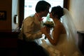 Bride and groom hold each other hands sitting in the cosy corner