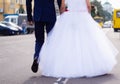 The bride and groom hold hands themselves while they walking on the road in city. Wedding in detail Royalty Free Stock Photo