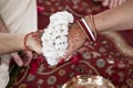 The bride and groom hold hands tied with a garland of white flowers. Beautiful traditional Indian wedding ceremony Royalty Free Stock Photo