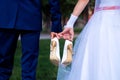 The bride and groom hold the shoes of the bride between themselves and hold hands with their little fingers. Wedding in detail Royalty Free Stock Photo