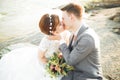 Bride and groom holding beautiful wedding bouquet. Posing near river Royalty Free Stock Photo