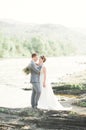 Bride and groom holding beautiful wedding bouquet. Posing near river Royalty Free Stock Photo