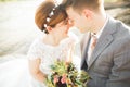 Bride and groom holding beautiful wedding bouquet. Posing near river Royalty Free Stock Photo