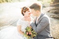 Bride and groom holding beautiful wedding bouquet. Posing near river Royalty Free Stock Photo