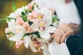 A bride and groom holding a bouquet of white and pink flowers Royalty Free Stock Photo