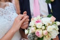 Bride and groom holding hands with bridal bouquet