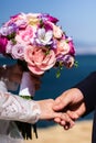 Bride and groom holding hands together on a sea coast. Royalty Free Stock Photo