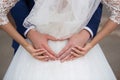 Bride and groom holding their hands in a heart shape Royalty Free Stock Photo