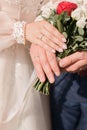 bride and groom holding wedding bouquet and showing their wedding rings Royalty Free Stock Photo