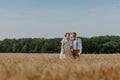 Bride and groom holding wedding champagne glasses on the background of wheat field. Happy wedding couple in wheat field Royalty Free Stock Photo