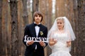 Bride and groom holding wooden letters love forever