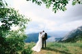 Bride and groom hug on Mount Lovcen against the backdrop of the panorama of the Kotor bay