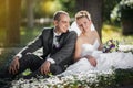 Bride and groom hugging and looking in the eyes of one another sitting at a green grass Royalty Free Stock Photo