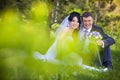 Bride and groom hugging and looking in the eyes of one another sitting at a green grass Royalty Free Stock Photo