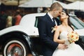 Bride and groom hugs in the front of old car Royalty Free Stock Photo